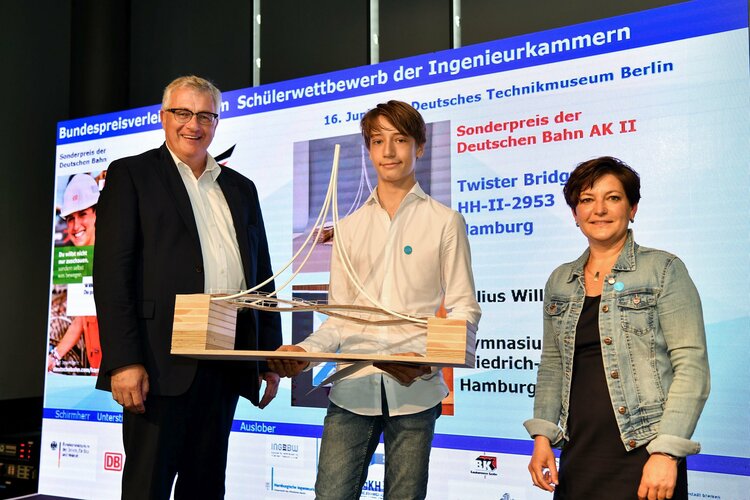 Preisverleihung Schülerwettbewerb Junior.ING der Ingenieurkammern: Julius Willich vom Gymnasium Kaiser-Friedrich-Ufer (Hamburg) erhielt in der Alterskategorie ab Klasse 9 den DB Sonderpreis für sein Brückenmodell "Twister Bridge". Der Vizepräsident der Bundesingenieurkammer, Ingolf Kluge (links) überreichte dem Schüler gemeinsam mit Ellen Petersson, Leiterin Lean Exzellenz, Deutsche Bahn die Urkunde. 