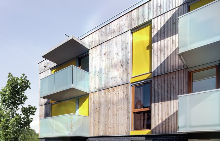 Fenstermarkisen an einem Mehrfamilienhaus mit Glasbalkonen