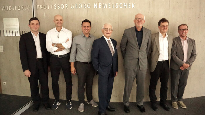 Prof. Georg Nemetschek im gleichnamigen Auditorium der HM (Mitte) gemeinsam mit Dr. Josef Böck, Stiftungsvorstand der Nemetschek Innovationsstiftung, umringt vom Kernteam des AInspect2Twin Projektteams