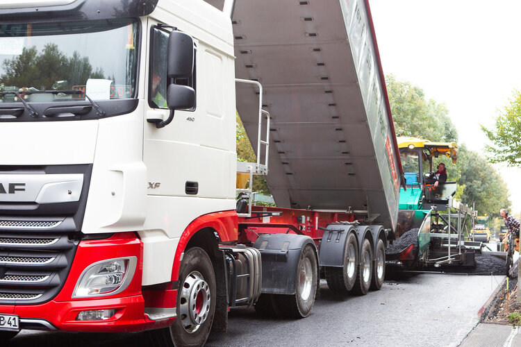 Bau der Versuchsfelder in Münster auf der der Teststecke zum emissionsarmen Asphaltstraßenbau: ein LKW lädt Asphaltgranulat ab