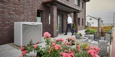  Außeneinheit der Luft/Wasser-Wärmepumpe neben dem Eingangsbereich des Hauses aufgestellt