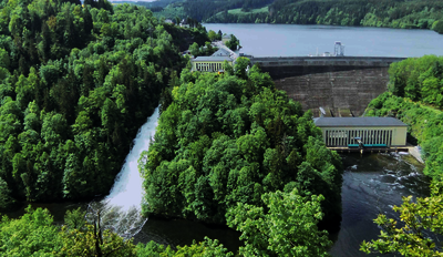 Die Staumauer der Bleilochtalsperre mit Kraftwerksgebäude, Hochwasserentlastungsrinne (links) und Ausgleichsbecken (Blick von Nordosten).