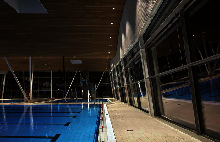 Die großen Becken in der Sporthalle erforderten größere Stützweiten – nur drei baumartig gestaltete Stahlstützen wurden im Raum positioniert.