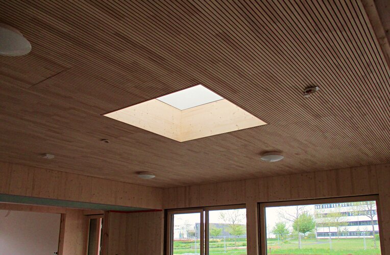 Durch das Setzen von Lichtkuppeln in Holzdecken kommt die Sonne in die Innenräume 