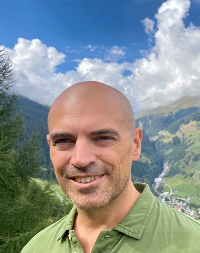 Greg Demchak oberer Oberkörper vor dem Hintergrund einer Bergkulisse