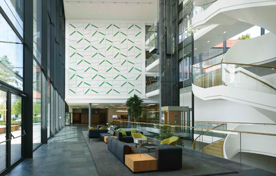 Das lichtdurchflutete Foyer ist zugleich das „Tor zum Campus“. Von hier gelangt man in die zwei Büroriegel, in den Schulungsbereich und zur Kantine. Die 13 m x 13 m große Installation „Grünheiner Feld“ ist vom Dresdner Künstler Sebastian Hempe
