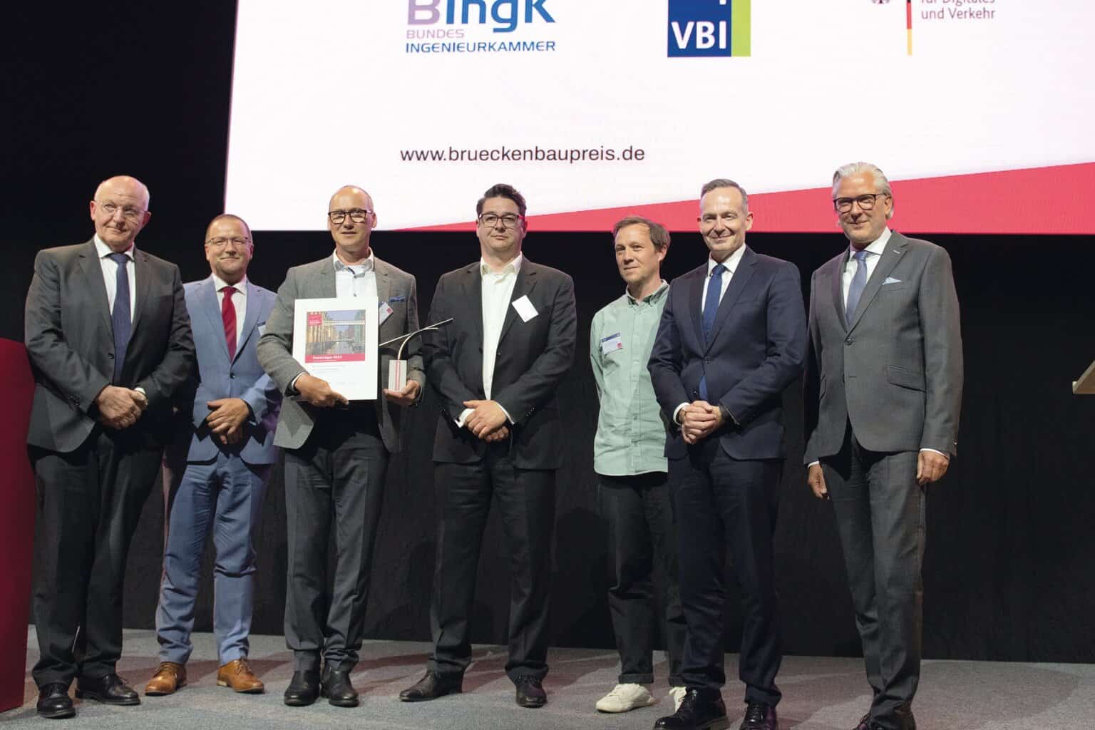 Preisverleihung beim Deutscher Brückenbaupreis 2023 (v.l.n.r.): Dr.-Ing. Heinrich Bökamp (Präsident BIngK), MR Prof. Dr.-Ing. Gero Marzahn (BMDV), Dr.-Ing. SFI Christian Böttcher (panta ingenieure), Dipl.-Ing. Architekt Enrico Kleinke (studioH2K Architekten), Dipl.-Ing. Arch. Alexandre Rombourg (HHLA Immobilien, Bauherrenvertreter), Dr. Volker Wissing (Bundesminister für Digitales und Verkehr), Dipl.-Ing. Jörg Thiele (Präsident VBI) (Foto: Yerko Romero Viveros)