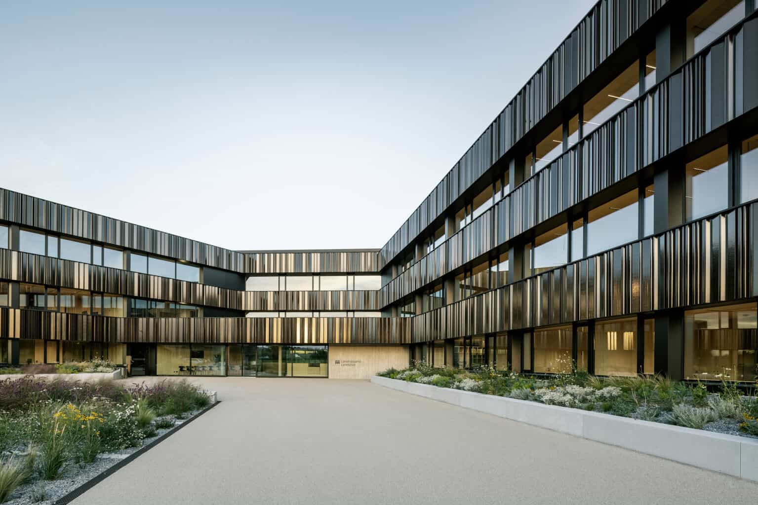 Der Neubau des Landratsamts Landshut fasst rund 600 Arbeitsplätze der Kommunalverwaltung an einem Standort zusammen. Über einen großzügigen Vorplatz zum Haupteingang hin, der in das verbindende Atrium führt, erhält das neue Landratsamt eine repräsentative Adresse. © Henrik Schipper Photography