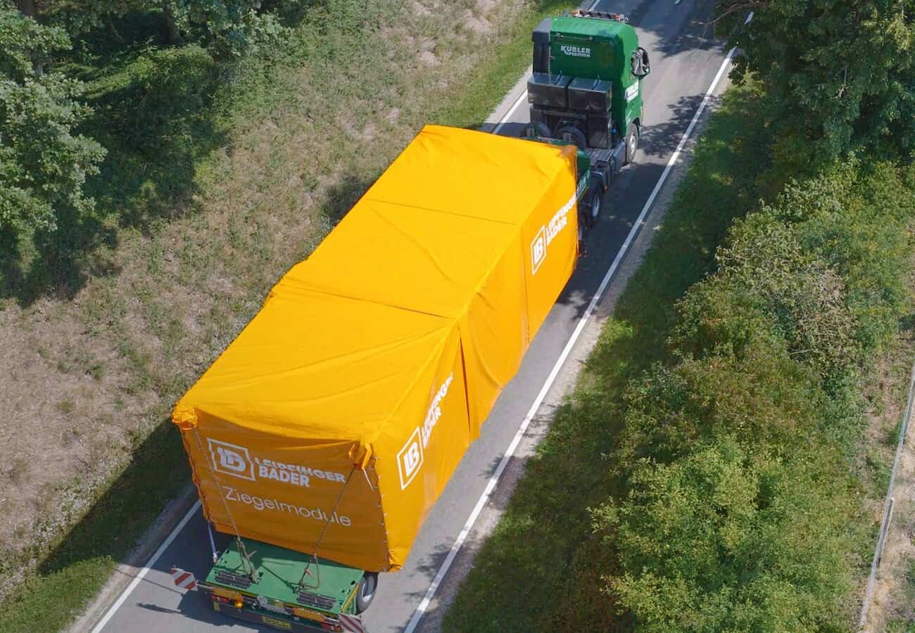 Die massiven Module von Leipfinger-Bader werden per LKW zur Baustelle transportiert und dort mit dem Autokran gehoben und gestellt. © Leipfinger-Bader
