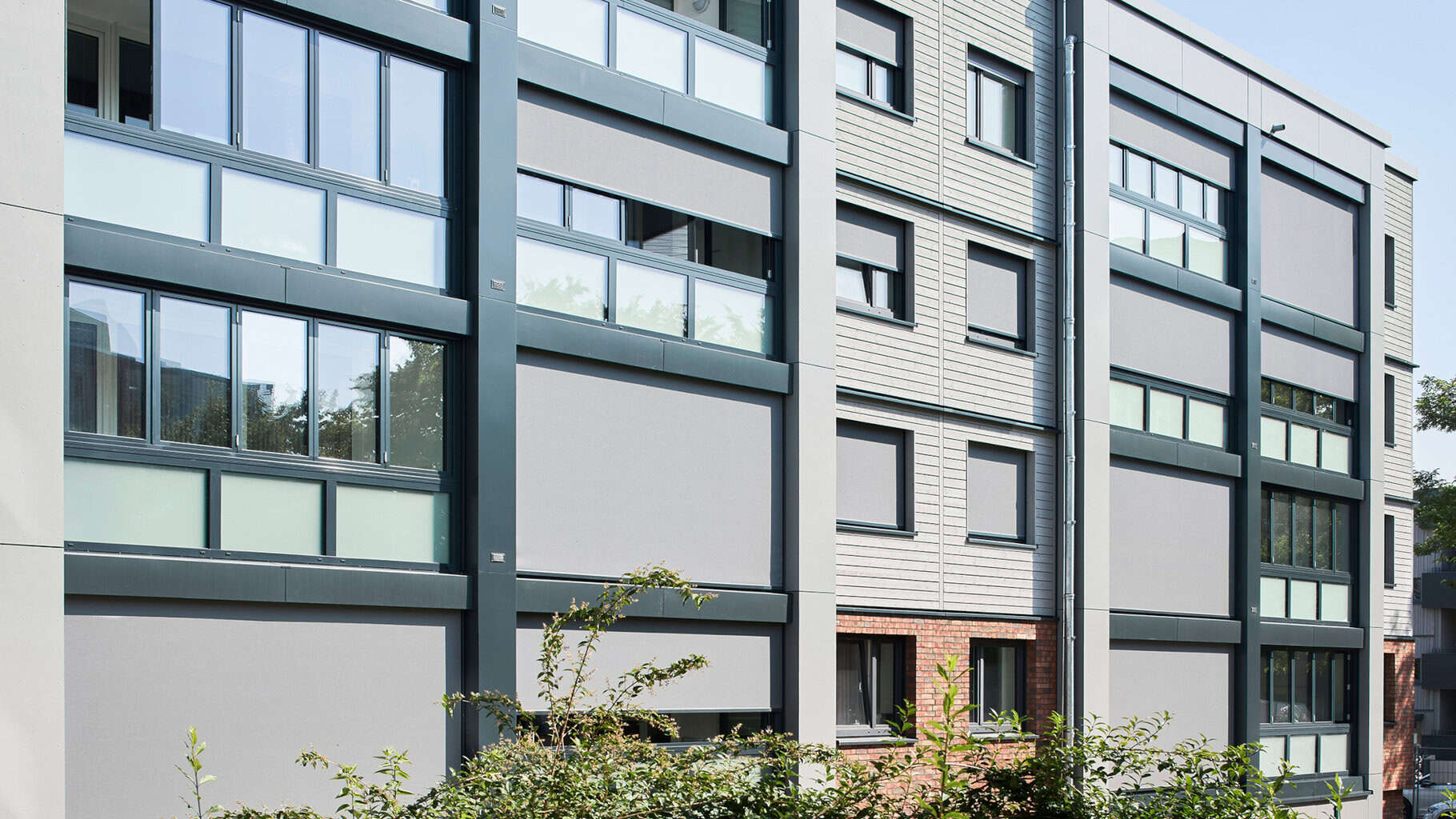 Die vorgehängten Falt-Schiebe-Fenster aus Aluminium werten die Loggien zu ganzjährig nutzbarem Wohnraum auf und stellen die Förderfähigkeit des Projekts sicher. © Lioba Schneider / Schüco International KG