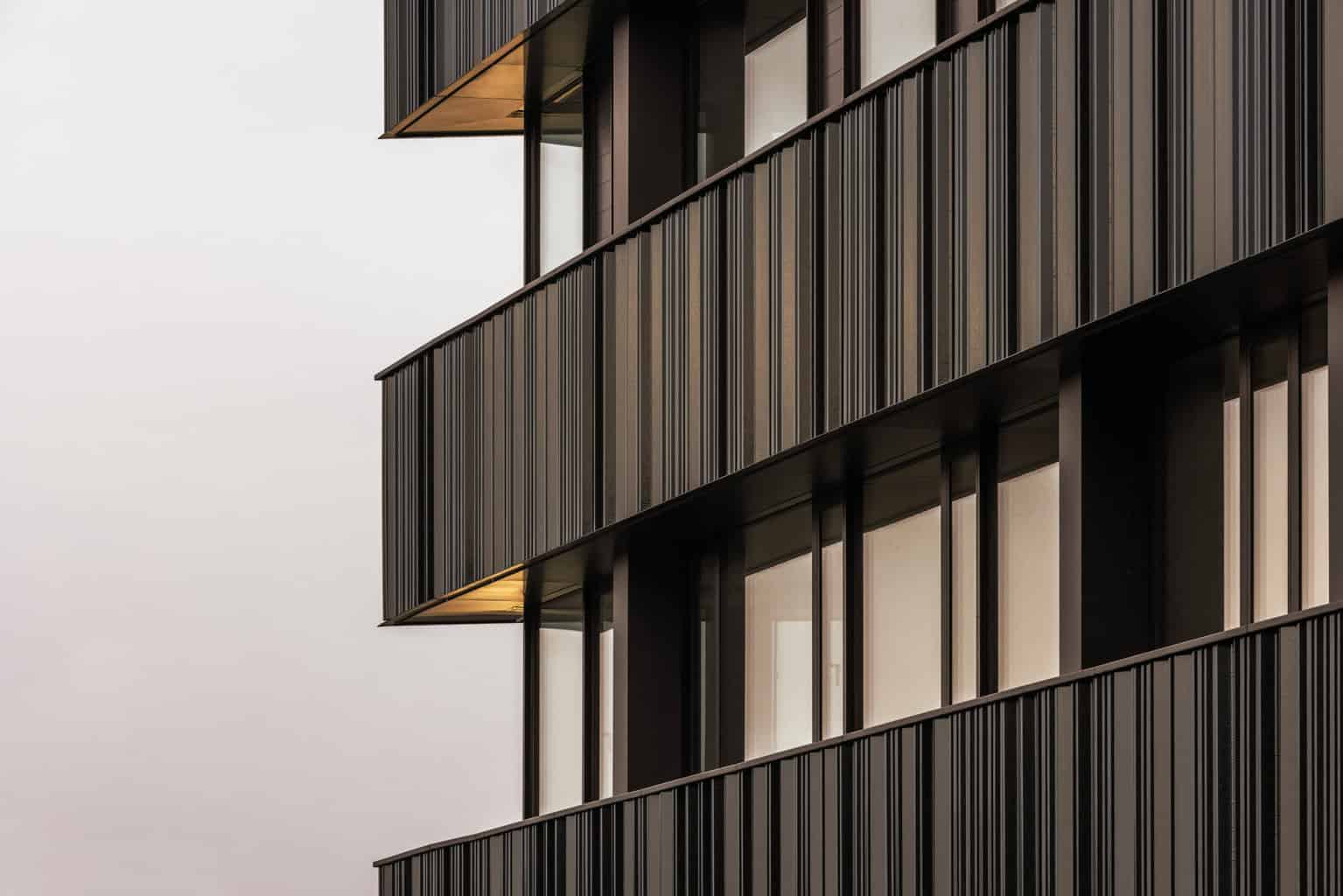 Ein schwarzer Scherben mit teiltransparenter Glasur sowie die gefaltete Anordnung der Keramikelemente sollen zu einer lebendigen, plastisch anmutenden Gebäudehülle beitragen. © Henrik Schipper Photography