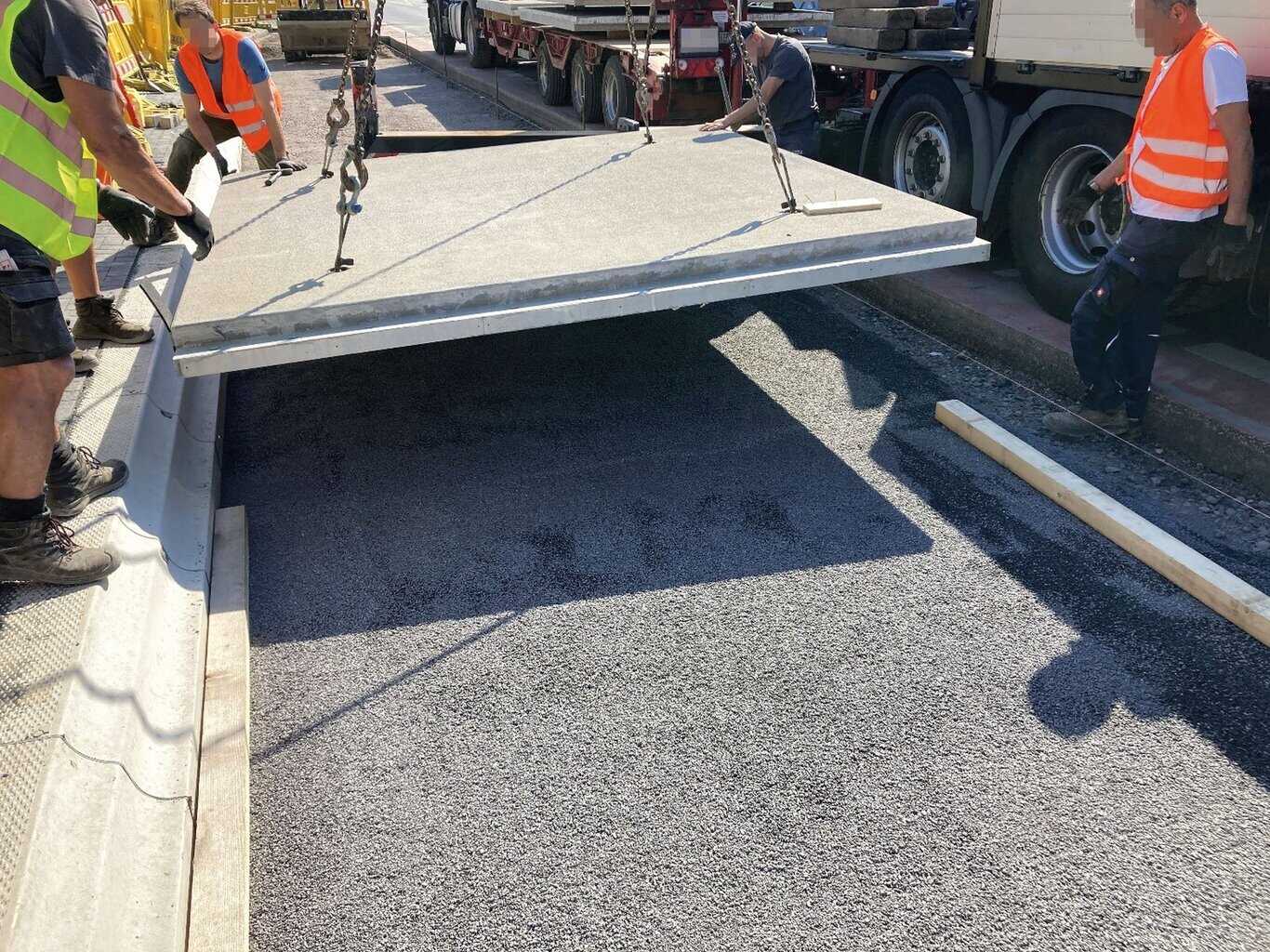 Einsetzen einer Verkehrsflächenplatte auf der Testbaustelle „Bushaltestelle Hessenhalle“ in der Stadt Gießen. © Foto: PT Ingenieur GmbH