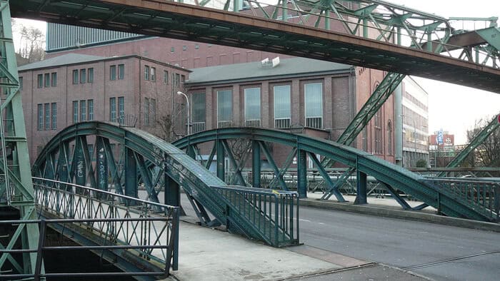 Vor der Sanierung: Die 125 Jahre alte Brücke mit genietetem Bogenfachwerk und darüber die Wuppertaler Schwebebahn. © Wikimedia/atamari