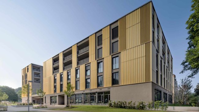 Mit dem Komplex „henA“ haben Schwille Architekten im Tübin-ger Viertel Hechinger Eck Nord einen auffälligen Quartiersbau in Holz-Hybrid-Bauweise realisiert, der viele Funktionen vereint: Grundschule, Seniorenheim, Wohnungen, Gewerbe. © Martin Baitinger / Sto SE & Co. KGaA
