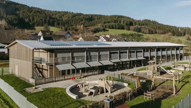 Der langgestreckte Baukörper des Kindergartens Sterntaler erinnert an eine traditionelle Schwarzwaldscheune. Diese „Kinderscheune“ soll Schutz und Geborgenheit vermitteln – und zugleich Offenheit. © MHZ, Raissa Axmann