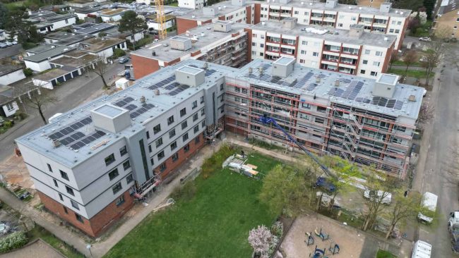 Drei viergeschossige und ein sechsgeschossiger Riegel mit über 100 Wohneinheiten werden seit 2024 in Düsseldorf-Urdenbach von der Holzunion seriell saniert. © HU-HOLZUNION, Rotenburg/Wümme