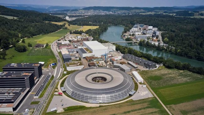 Im Rahmen der Dachsanierung des PSI-Synchrotrons in Villingen, Schweiz, wurde das dachintegrierte AluPlusSolar-System von Kalzip installiert, das die Modernisierung der bestehenden Gebäudehülle mit der Erzeugung erneuerbarer Energie in einer nahtlosen architektonischen Lösung kombiniert. © Kalzip GmbH