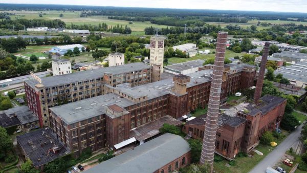 Aus der Luft wird deutlich, wie eng die Gebäude im Nähmaschinenwerk Wittenberge nebeneinanderstehen – hier (von hinten nach vorn) das Gebäude 22 mit dem Wasser- und Uhrenturm, das Gebäude 07 sowie Hauptwerkstatt und Krafthaus. (Foto: Lost Adventure Tom)