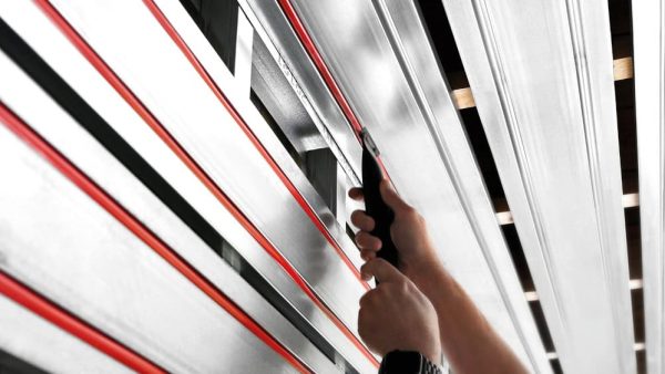 Eindrücken der Schlauchleitungen in die raumseitigen Hohlkehlen der Aluminiumprofile. © Dennert Baustoffwelt