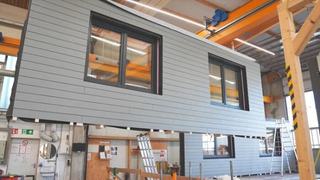 Die Fassadenelemente werden in der Werkshalle vollständig vormontiert