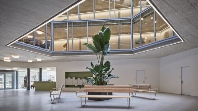 Der zentrale Lichthof schafft als ‚Dorfplatz‘ eine offene und lichtdurchflutete Begegnungszone. © Damian Poffet