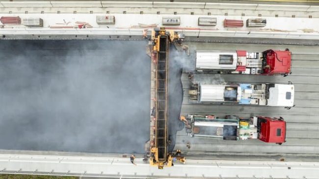 Auf dem nördlichen Überbau wird die Bitumenschweißbahn aufgebracht, bevor die Vorlegestreifen angebracht und der Gussasphalt im Fahrbahnbereich eingebaut werden.© PORR