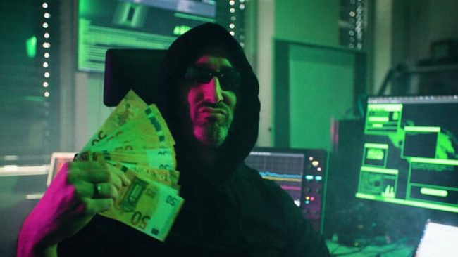 Eigentlich ist Dominik Merli Professor für IT-Sicherheit an der Technischen Hochschule Augsburg. Im Song „Cyber Gangsta’s Paradise“ schlüpft er in die Rolle des böswilligen Hackers MC BlackHat. In seinem Musikvideo prangert Prof. Merli Missstände bei der Cybersicherheit von Produkten an. © Jonah Stiller/Langesicht Filmproduktion