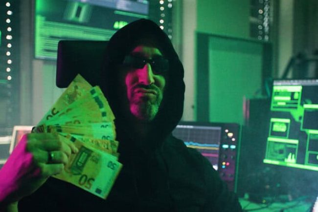 Eigentlich ist Dominik Merli Professor für IT-Sicherheit an der Technischen Hochschule Augsburg. Im Song „Cyber Gangsta’s Paradise“ schlüpft er in die Rolle des böswilligen Hackers MC BlackHat. In seinem Musikvideo prangert Prof. Merli Missstände bei der Cybersicherheit von Produkten an. © Jonah Stiller/Langesicht Filmproduktion