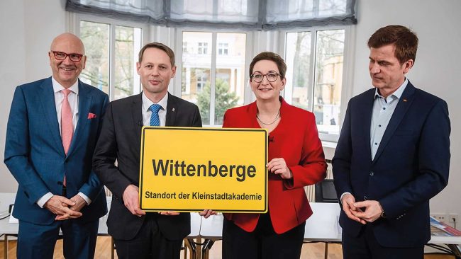 Symbolische Ortsschildübergabe für den Standort der neuen Kleinstadtakademie (v.l.n.r.): Dr. Uwe Brandl (Präsident DStGB), Martin Hahn (Bauamtsleiter Wittenberge), Klara Geywitz (Bundesministerin für Wohnen, Stadtentwicklung und Bauwesen), Dr. André Berghegger (Hauptgeschäftsführer DStGB) © BMWSB – Henning Schacht